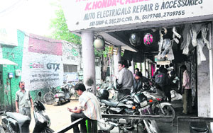Mechanics repair two-wheelers in the Sector 21 market in Chandigarh. 