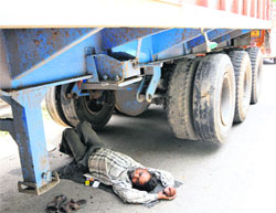 A driver takes nap under the truck to save himself from scorching heat in Jammu on Thursday.