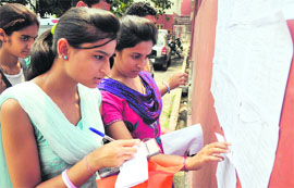 Students search for their names in the second merit list at Government College for Women at Parade in Jammu on Thursday.