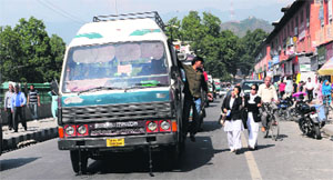 Mini buses ply on a road in a market near the Lal Chowk in Srinagar. 
