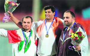 Vikas Gowda, flanked by silver medalist Mahammad Samimi (left) and bronze medalist Ahmed Mohammed Dheeb, at the victory ceremony on Thursday. 
