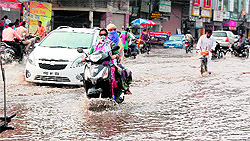 Residents face a tough time commuting on a flooded road