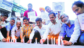 PGI employees light candles after a protest march at Sector 17 in Chandigarh on Friday.