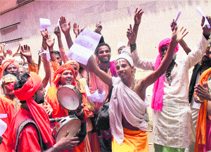 Devotees sing religious songs as they wait to register themselves for the Amarnath pilgrimage at a base camp in Jammu. 