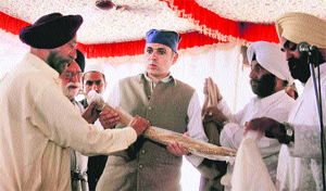 Sikhs present a sword to Chief Minister Omar Abdullah during the birth anniversay of Guru Hargobind in Srinagar on Friday. 