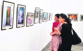 Celebrating art: Visitors take a look at the paintings made by children during an exhibition in Amritsar on Saturday