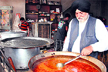 Surinder Singh Ahluwalia, owner of Amritsari Dhaba, stirs a pot full of mutton delicacy in Bathinda on Saturday