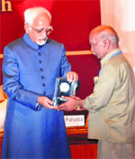 Vice-President Hamid Ansari presents a memento to Kartar Singh at the PGIs 51st foundation day function in Chandigarh on Saturday. 