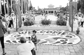 A man clicks the photograph of a child in the backdrop of a rangoli at Pinjore Garden on Saturday.