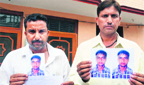 Relatives show photograph of the boy who has gone missing from Jalandhar.