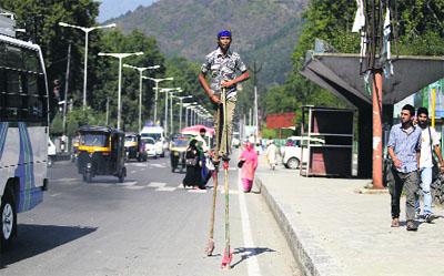 An artiste performs amid the flow of traffic at Maulana Azad road in Srinagar on Saturday.