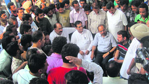 BJP workers, led by Pathankot MLA Ashwani Sharma, take up their grievances with Mukerian SDM Rahul Chaba (in black T-shirt) at the toll plaza near Mukerian on Saturday. 