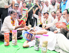 Former municipal councillor Vijay Kumar (left) along with residents of Parasram Nagar protests against the spiralling prices of vegetables in Bathinda on Sunday. 