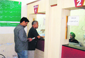 Residents stand in a queue at a computerised a Fard Kendra in Mohali. 