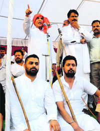 Two Congress workers with lathis provide security to local MP Pawan Kumar Bansal at a rally in Chandigarh, where the clash took place on Sunday.