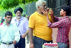A man getting his teeth cleaned with a medicine near Patel Chowk Metro Station in New Delhi on Sunday