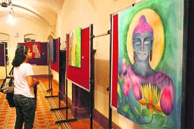 A girl admires a painting exhibition at the Gaiety Theatre in Shimla on Sunday