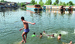 A boy jumps into the Dal Lake in Srinagar on Sunday. The city witnessed a sudden rise in temperature over the past few days