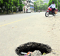 A pothole on the road in front of the Ludhiana Stock Exchange near the Feroze Gandhi market poses danger for motorists