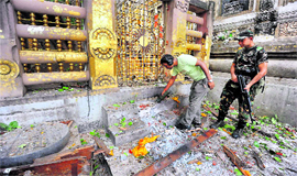 Security personnel inspect the explosion site after blasts at the Mahabodhi Temple complex in Bodh Gaya on Sunday.