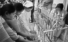 People light candles at the end of mass prayer for victims of Uttarakhand disaster in Kolkata on Friday.