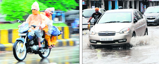 : A couple uses polythene sheets to protect themselves from rain; and vehicles (right) wade through a waterlogged road in Amritsar on Monday.