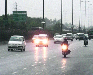 Motorists drive with headlights on amid a drizzle on the Delhi-Gurgaon Expressway on Monday afternoon. 