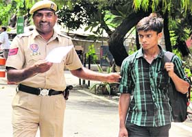 Gopal Dubey, who enacted a drama of his kidnapping, with a police personnel in Jalandhar on Monday