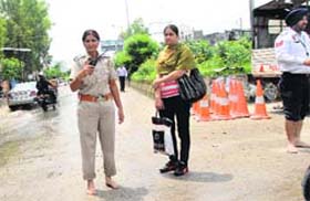 DUTY BOUND: Traffic police officials perform duty barefoot at BSF Chowk as their shoes got wet after a heavy rain in Jalandhar on Monday
