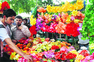 People purchase artificial flowers from a vendor in Srinagar. 