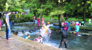 Children swim in water to beat the heat in Srinagar on Monday.