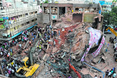 Rescue workers remove bodies from the rubble at the site of the building collapse in Secunderabad on Monday.