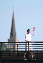 Murray waves to the crowd from a walk way backdropped by the Wimbledon Village Church.