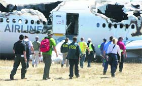 A probe team arrives to inspect the wreckage of Asiana Flight 214 in San Francisco on Sunday