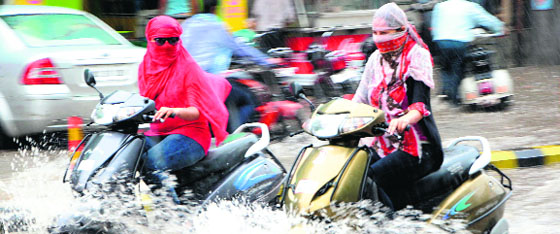 Girls on two-wheelers wade through rainwater on Lawrence Road in Amritsar on Tuesday. 