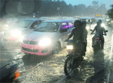 Traffic moves slowly on a waterlogged road at ITO in New Delhi on Tuesday. 