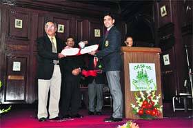 Additional Director General, Forests, SS Garbyal, presents a gold medal to Sunny Verma of Himachal Pradesh in Dehradun on Tuesday