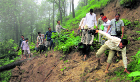 People find their way through a landslide at Padhar division in Mandi on Tuesday.