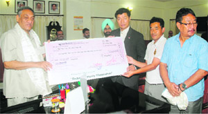 Labsang Sangay, Tibetan Prime Minister-in-exile, gives a cheque to Chief Minister Vijay Bahuguna in Dehradun on Wednesday. 