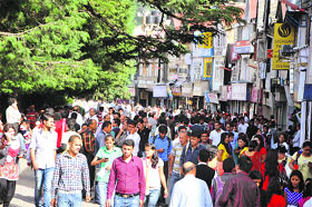 People walk in the busiest market in Shimla on Wednesday on the eve of World Population Day