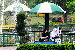 A group of college students settles for a spot in a park on a rainy day in Srinagar on Wednesday