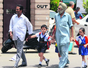 Parents take their children home after  school on Wednesday in Ludhiana. 
