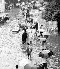 People wade through a flooded street in Mumbai on Wednesday. 