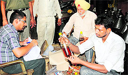 A Health Department team collects samples during a raid at an oil factory
