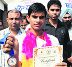 Gaurav Kumar, who won a bronze medal at the karate tournament organised in Bangkok, being accorded a warm welcome at Bathinda railway station. Tribune photo: Pawan Sharma 