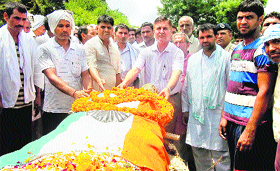 Jhajjar SDM Pradeep Dagar places a wreath on the body of Badlu Ram at Khachrauli village in Jhajjar on Thursday.