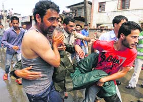 In face of catastrophe: An injured fireman being carried at the Secretariat building in Srinagar on Thursday