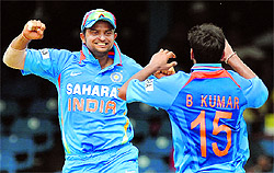 Suresh Raina, Bhuvneshwar Kumar celebrate the fall of a wicket during the Tri-Nation Series final against Sri Lanka in Port of Spain on Monday