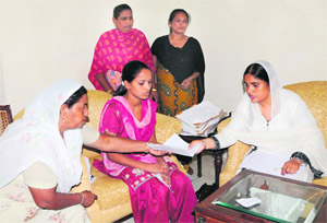 Paramjit Kaur (right), Punjab Women Commission Chairperson, listens to grievances of women in Amritsar on Friday