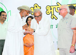 Haryana CM Bhupinder Singh Hooda honours a farmer at Kisan Bhawan in Panchkula on Friday.